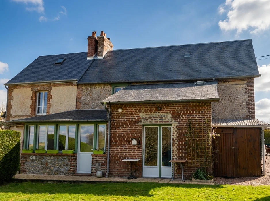 Maison de campagne normande en briques et silex, deux niveaux, toiture en ardoise avec lucarnes et cheminées en brique